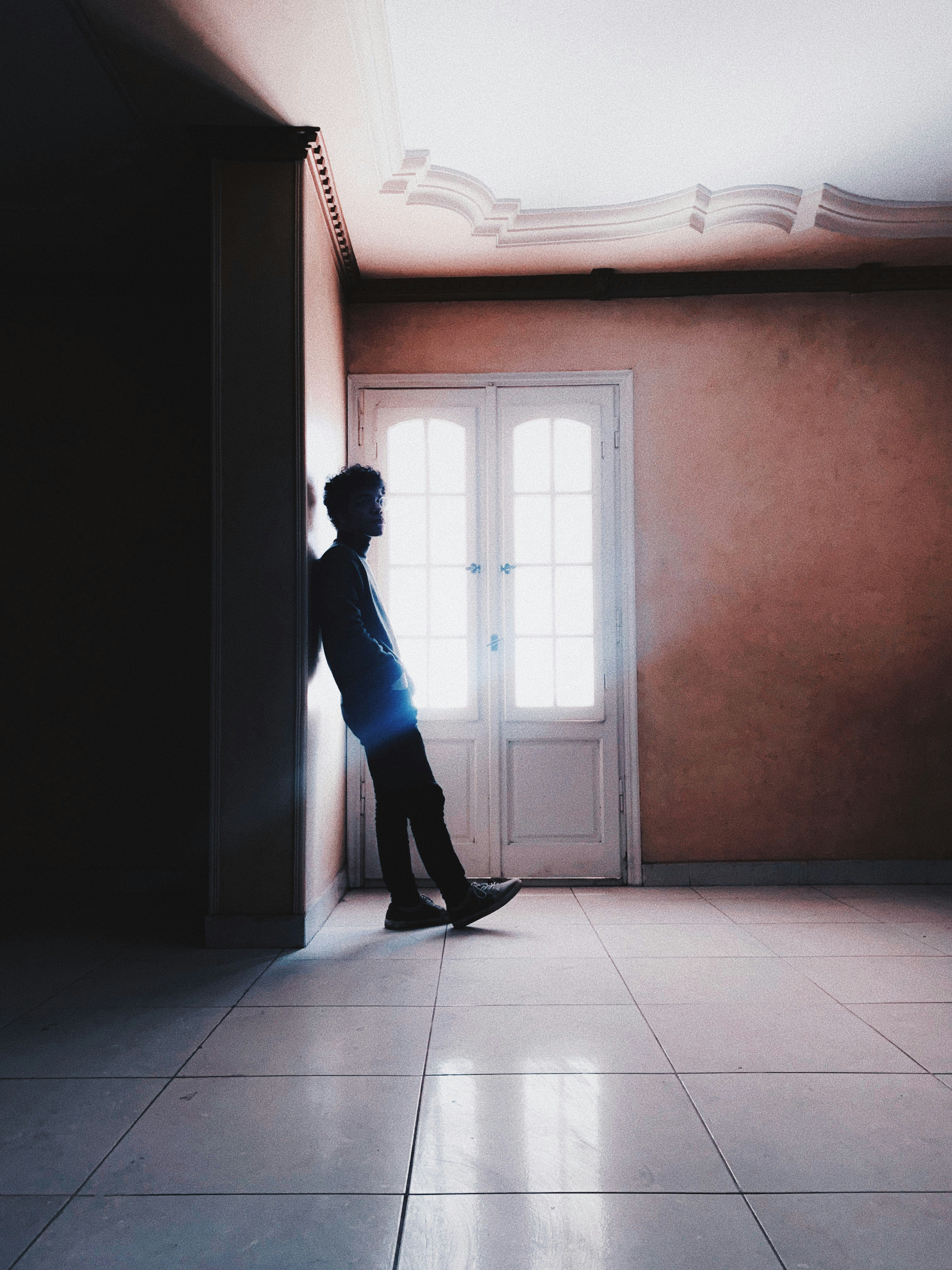 woman in blue long sleeve shirt and blue pants standing in front of window